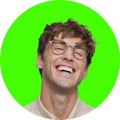 Smiling young man with tousled hair and glasses against a bright green circular background.